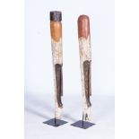 A PAIR OF WOODEN MASKS Tubular hand-carved, both secured on a steel base. The larger 121cm, the