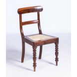 A STINKWOOD REGENCY-STYLE DINING CHAIR With curved top rail, caned seats on ring-turned and baluster