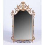 A GILT-METAL WALL MIRROR The arched super structure with a cresting of a basket of flowers flanked