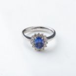 A TANZANITE AND DIAMOND RING BY BROWNS Claw-set to the center with a natural oval tanzanite weighing