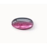 AN UNMOUNTED ELONGATED OVAL CABOCHON BI-COLOURED TOURMALINE