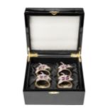 A CASED SET OF FOUR RHODIUM-COATED NAPKIN RINGS, ISABELLA ADAMS