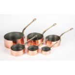 A SET OF SIX TIN-LINED COPPER SAUCEPANS WITH BRASS HANDLES