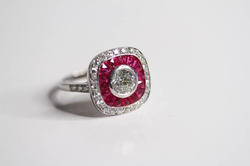 Calibre set RUBY and diamond ring. Central brilliant cut in a rub over setting surrounded by