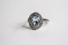 Platinum Oval Bezel Set Aquamarine And Diamond Cluster Ring, with 4 diamonds at focal points in