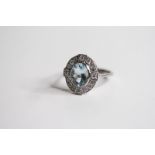 Platinum Oval Bezel Set Aquamarine And Diamond Cluster Ring, with 4 diamonds at focal points in