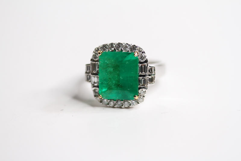 18ct Emerald and diamond ring. Step cut emerald 4.13 D1ct Halo of RB and baguettes double at