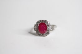 18ct Oval Ruby and Diamond Ring, with drop lock baguette style shoulders Ruby 2.47 D0.73 marked 750