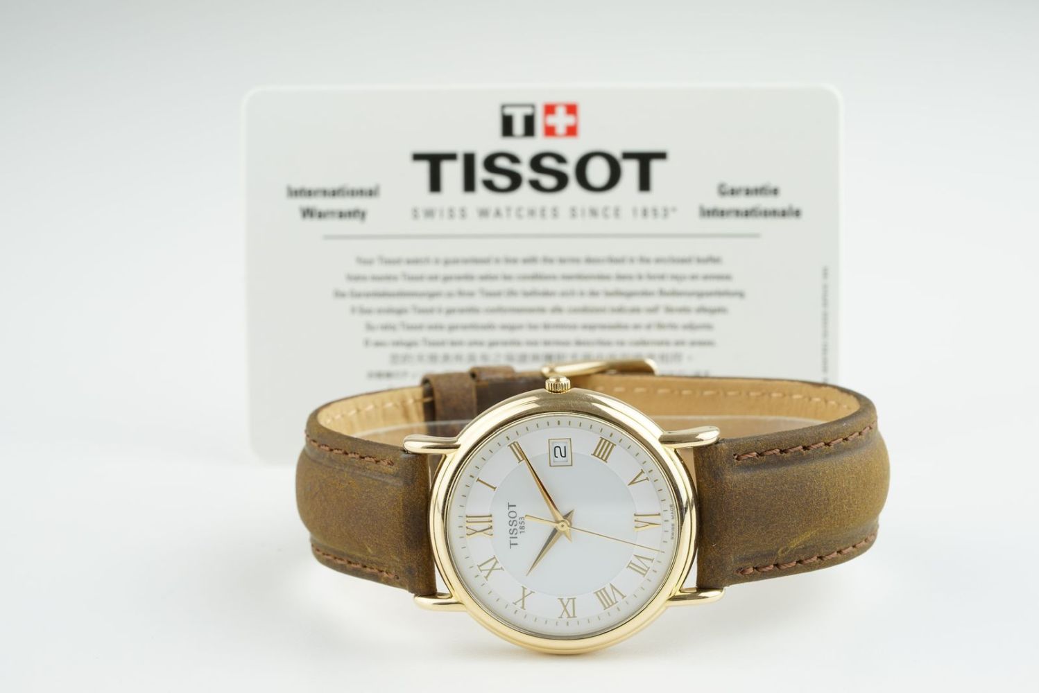 GENTLEMENS TISSOT 18CT GOLD DATE WRISTWATCH W/ WARRANTY CARD, circular white dial with roman numeral
