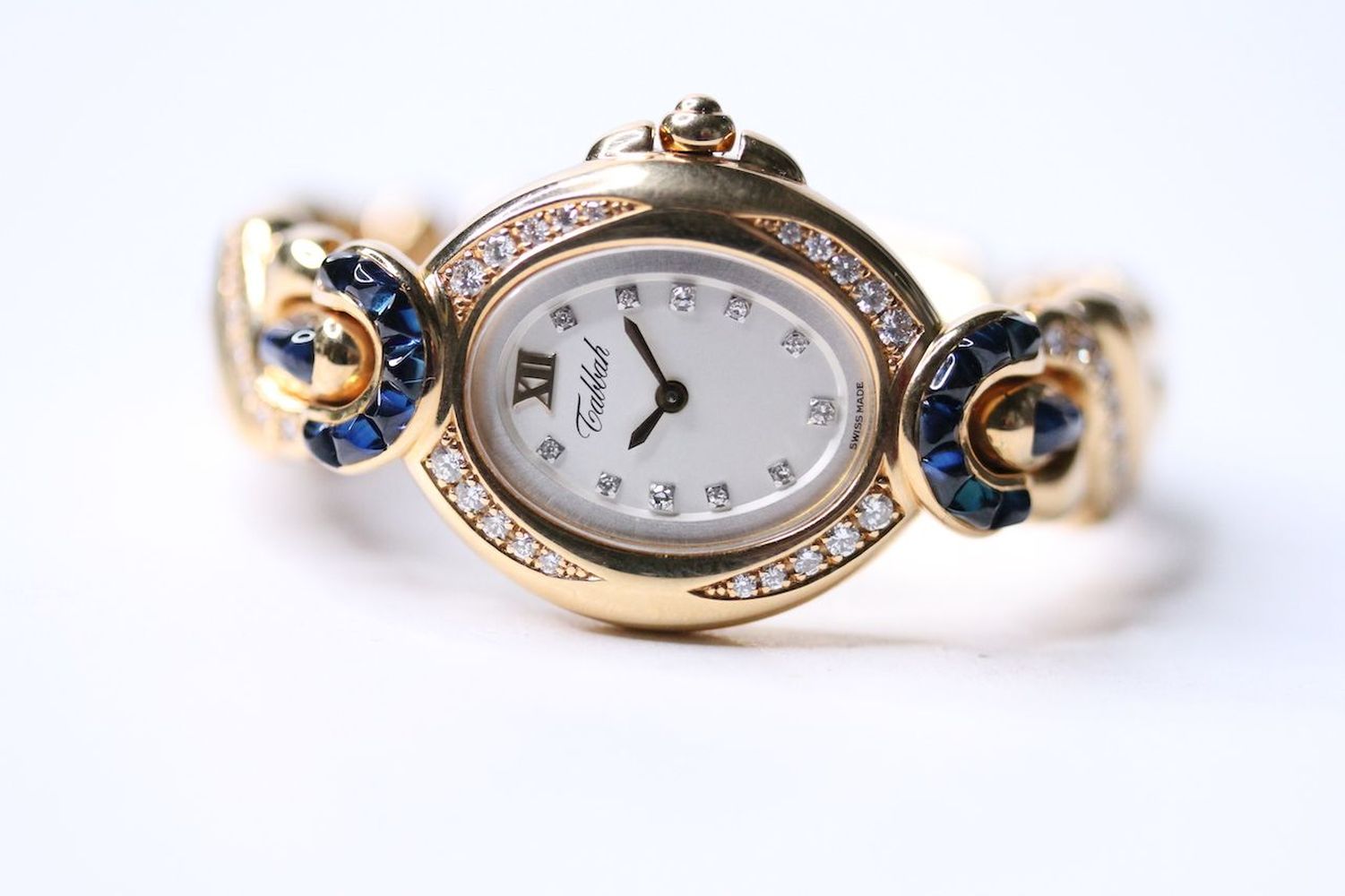 LADIES 18CT TABBAH COPACABANA DIAMOND AND SAPPHIRE BEZEL WRIST WATCH, oval silver dial with