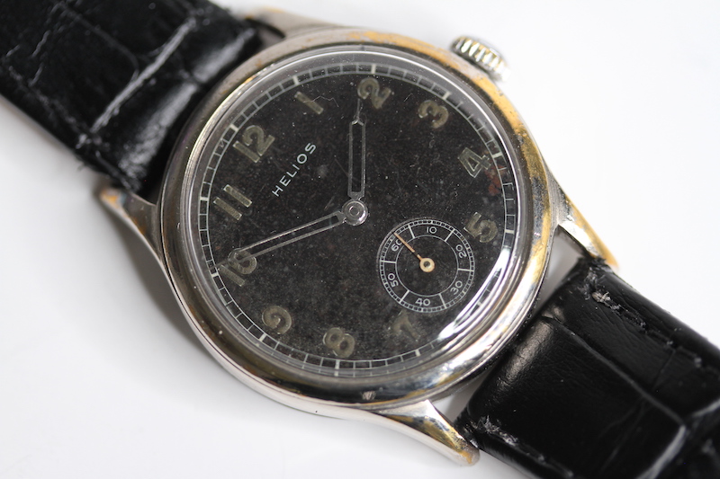 VINTAGE MILITARY HELIOS GERMAN ARMY D.H WRIST WATCH, black dial with open syringe hands, patina