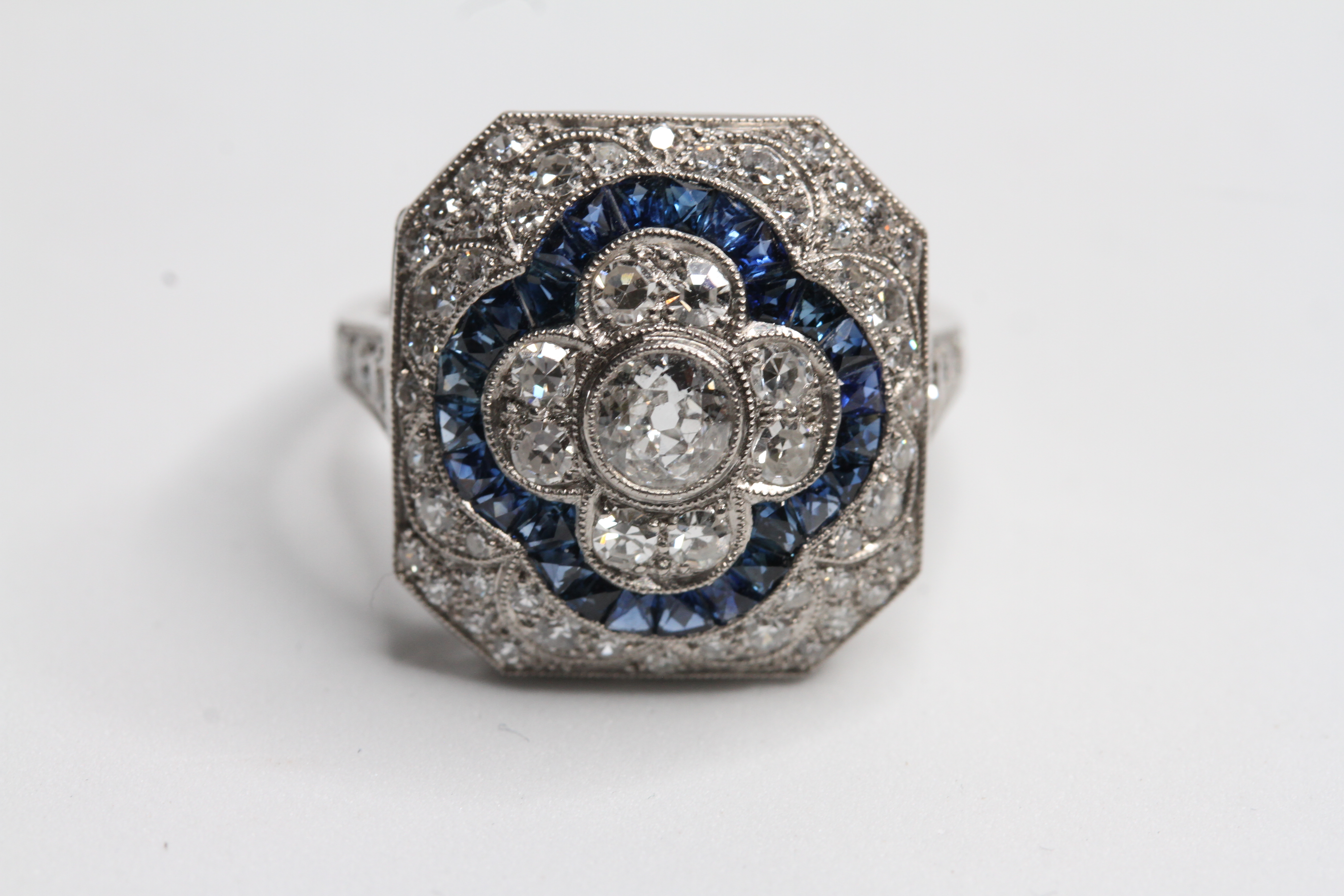 Platinum deco style ring with calibre sapphires and central diamond in 4 petal flower D 1.70ct
