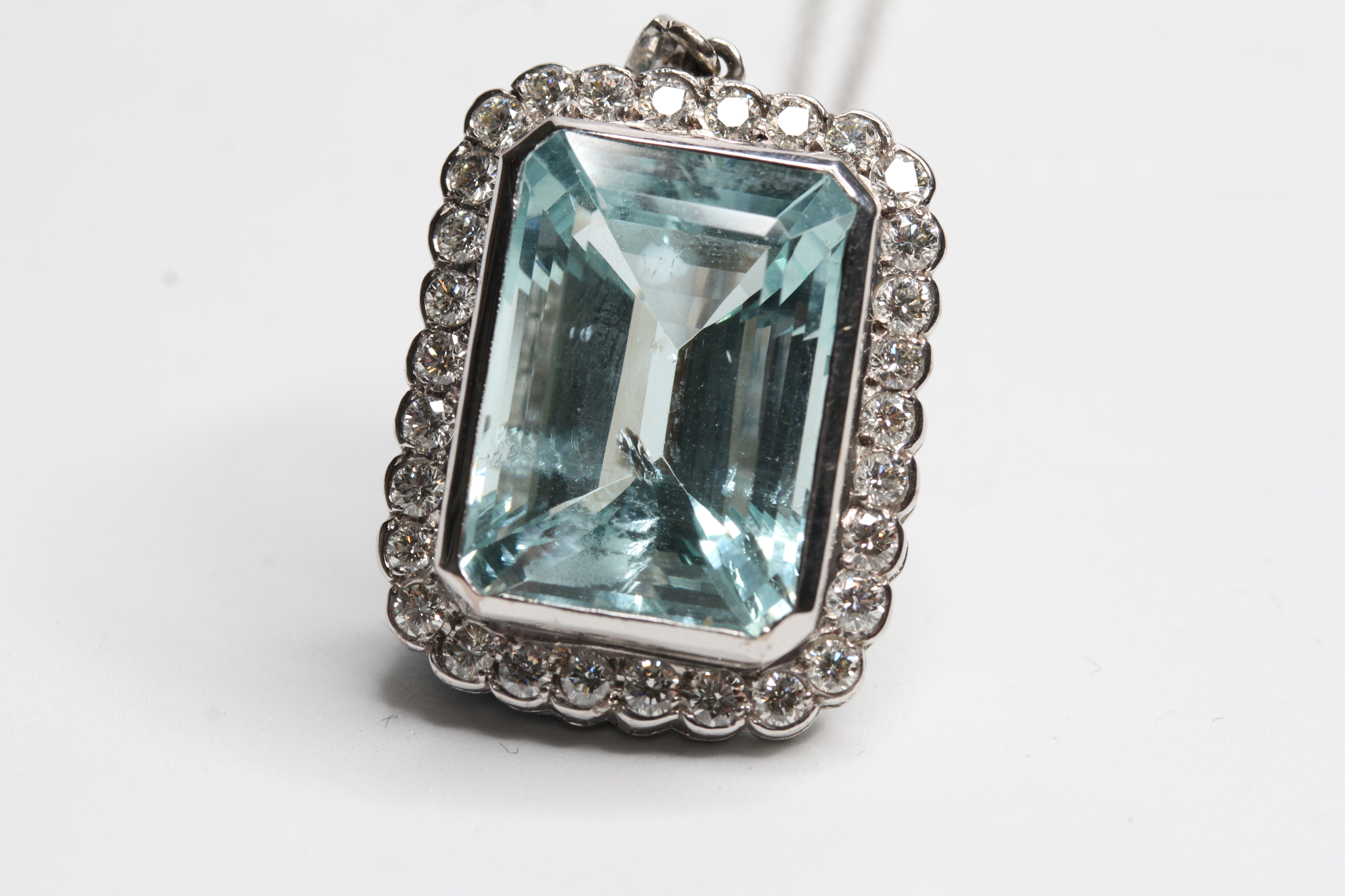 18WG Emerald cut aquamarine in a diamond framed pendant with diamond bale. Aqua 15 carats D1.25