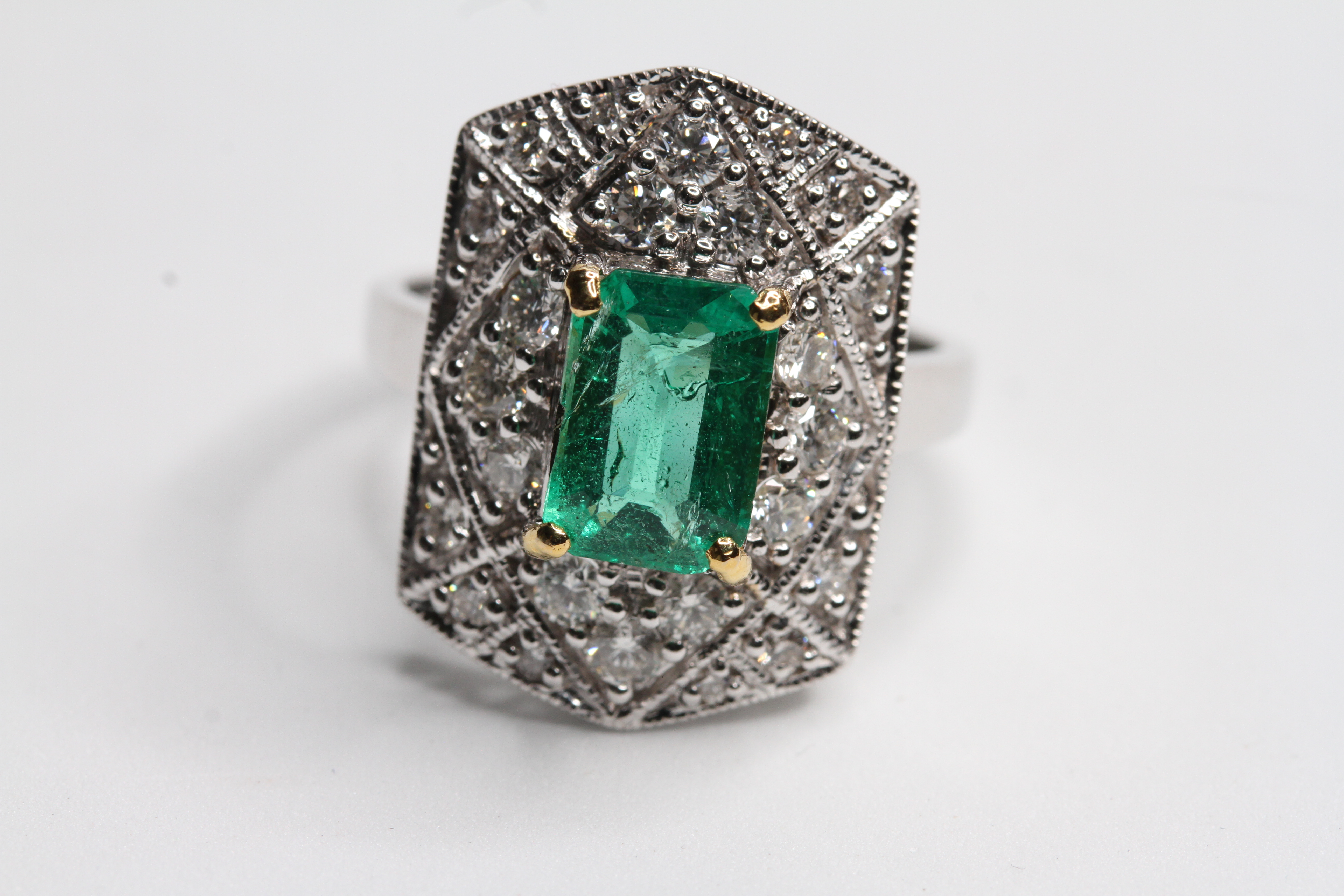 18WG Pave set diamond tablet ring with central claw set Emerald. EstE1.65 cts
