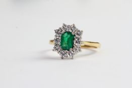 Emerald and diamond cluster ring, central emerald cut Emerald, approximately 6.5 x 4.5mm, surrounded