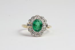 18ct Emerald and diamond ring. Central oval bezel set emerald surrounded by brilliant cut