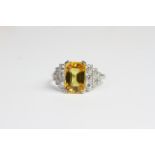 Platinum claw set emerald cut yellow sapphire and diamond deco style ring. YS 4 cts D 0.60 carats in