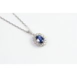 18ct bezel set oval sapphire and diamond cluster pendant on an 18WG chain 42cm/16 inches. S1.75ct
