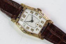 Art Deco 18ct enamel bezel watch, Tonneau shape engraved dial, with gilt Arabic numerals. Engraved