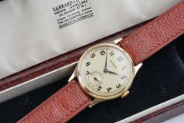 GARRARD 9CT GOLD WRISTWATCH W/ BOX, circular patina dial with arabic numeral hour markers and hands,