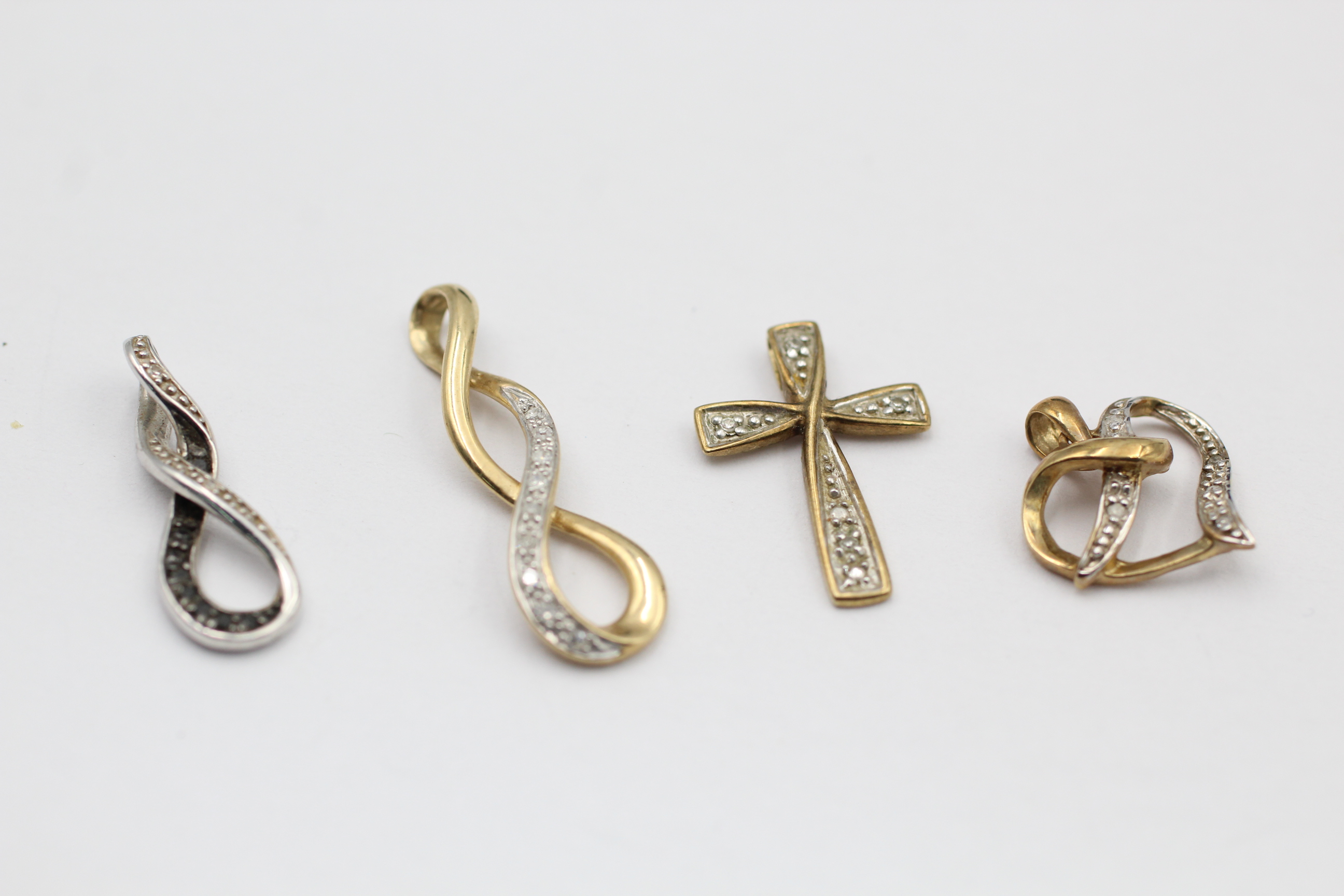 4 x 9ct gold diamond pendants inc. black diamond, religious cross, infinity (3.2g)