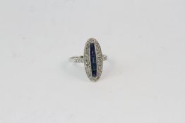 18WG vintage oval shaped ring with a central row of step cut sapphires