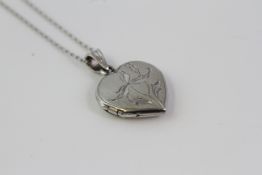 An engraved heart shaped opening locket suspended by a bale on a platinum chain.