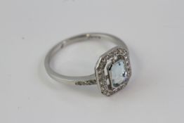 Platinum an open halo style ring with a central aquamarine in side a surround of round brilliant cu