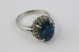 Marked PT900 this oval black opal and diamond ringalso