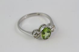 *In platinum an oval peridot and round diamond 3 stone ring in a ‘rub-over’ setting