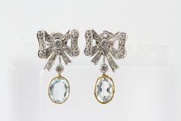 In yellow and white metal, diamond ribbon earrings with an oval aquamarine drop, marked 750