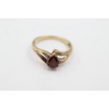 10ct gold diamond framed garnet ring weighs 1.9 grams. Set with a tear drop garnet and diamonds.