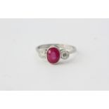 Oval ruby and diamond 3 stone ring in a rub-over setting. Ruby 1.65 carats Diamonds total 0.40