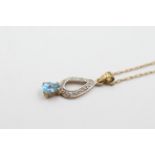 9ct gold diamond & topaz drop pendant necklace weighs 1.4 grams . Set with a blue tear drop topaz