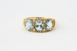 Yellow metal ring with 3 oval aquamarines