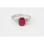 White gold ruby and diamond ring. The central ruby is set between 6 round cut diamonds, 3 on each