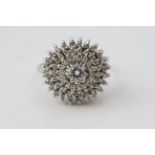 Diamond cluster bombe style ring with 3 tiers of diamonds surrounding the prominent centre