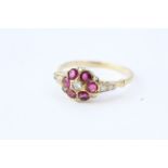 A ruby and diamond cluster ring with diamond shoulders.Worn stamp 18CT