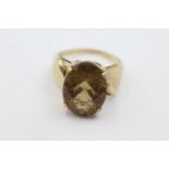 9ct gold twist band smokey quartz dress ring weighs 5.3 grams. Set with a trillion cut smokey