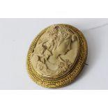 Antique yellow metal carved lava cameo brooch. Set in a yellow metal frame with a high relief