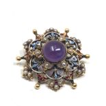 An antique 15 carat gold with enamel decoration, and set with an amethyst cabochon surrounded by