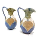 A pair of Royal Doulton stoneware ewers, with shaped rims and curved handles, pale blue and green