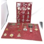 34 military cap badges mounted on board