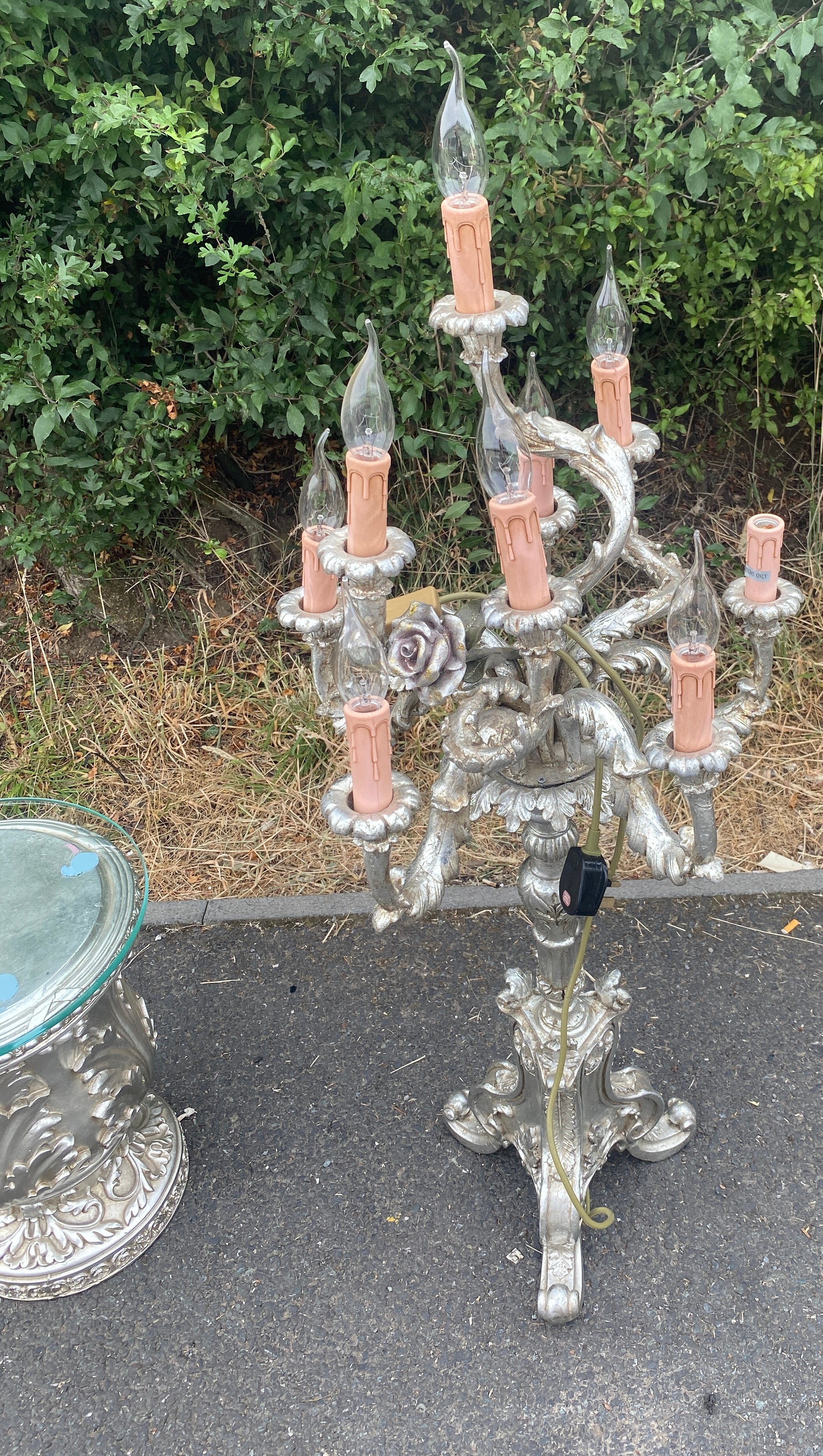 Silver coloured tall candelabra and glass topped side table, untested, approximate height of