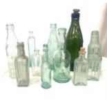 Selection of 12 vintage green, clear and blue glass medicine bottles
