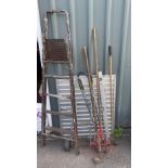 A set of metal ladders, a trolley and a selection of garden tools