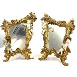 Pair of gilt framed cherub ornamental free standing mirrors measures approx 16 inches tall 11 inches