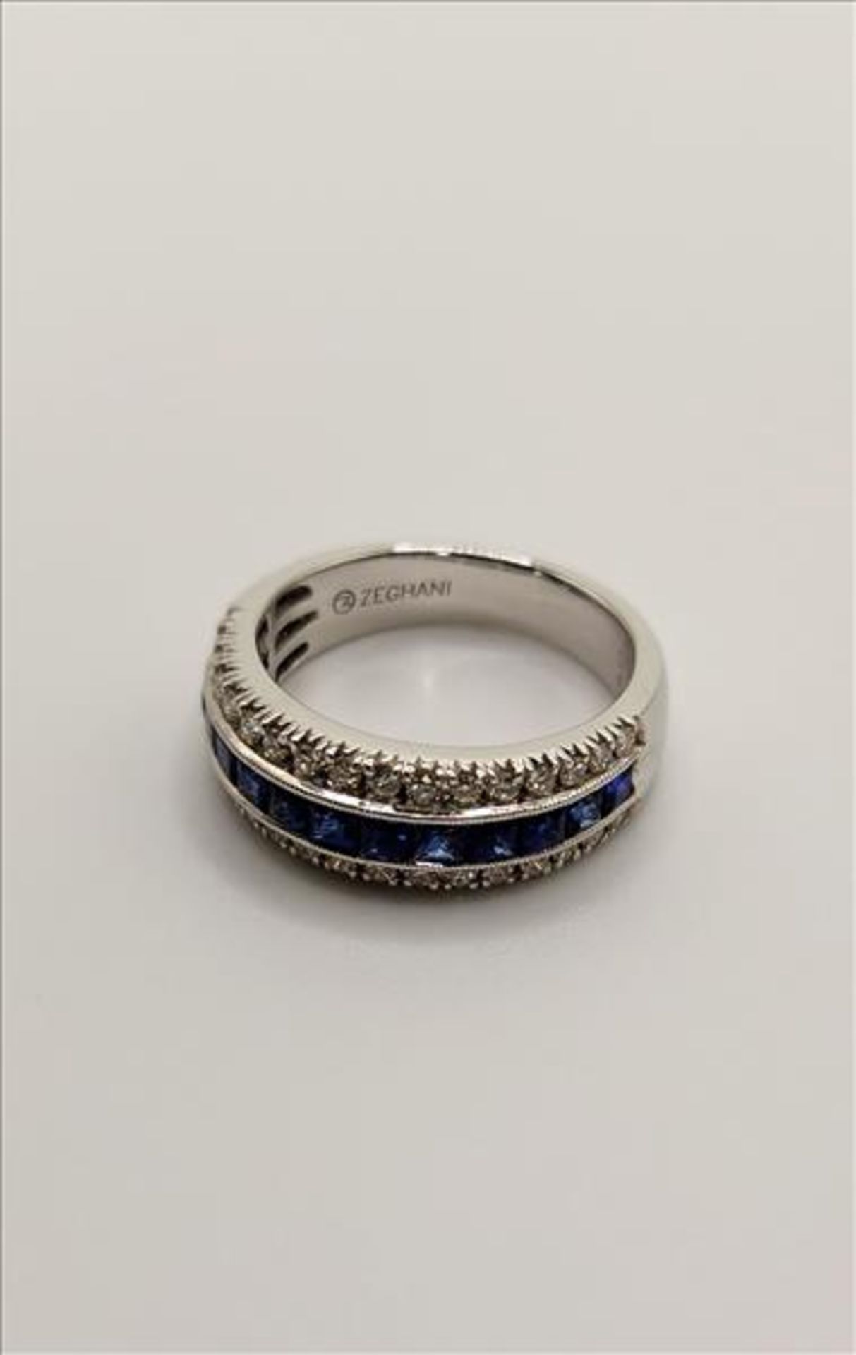 One lady’s stamped and tested 14kt white gold (Zeghani) sapphire and diamond band. Channel set