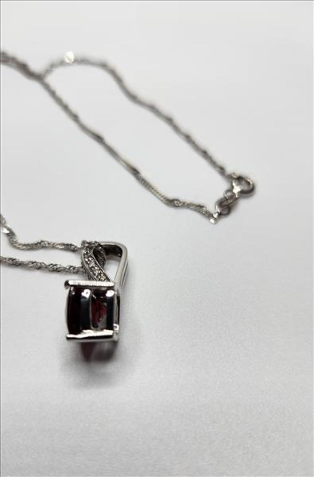 One lady’s stamped 14kt white gold Garnet and diamond pendant and 10kt white gold chain. Contained - Image 3 of 5