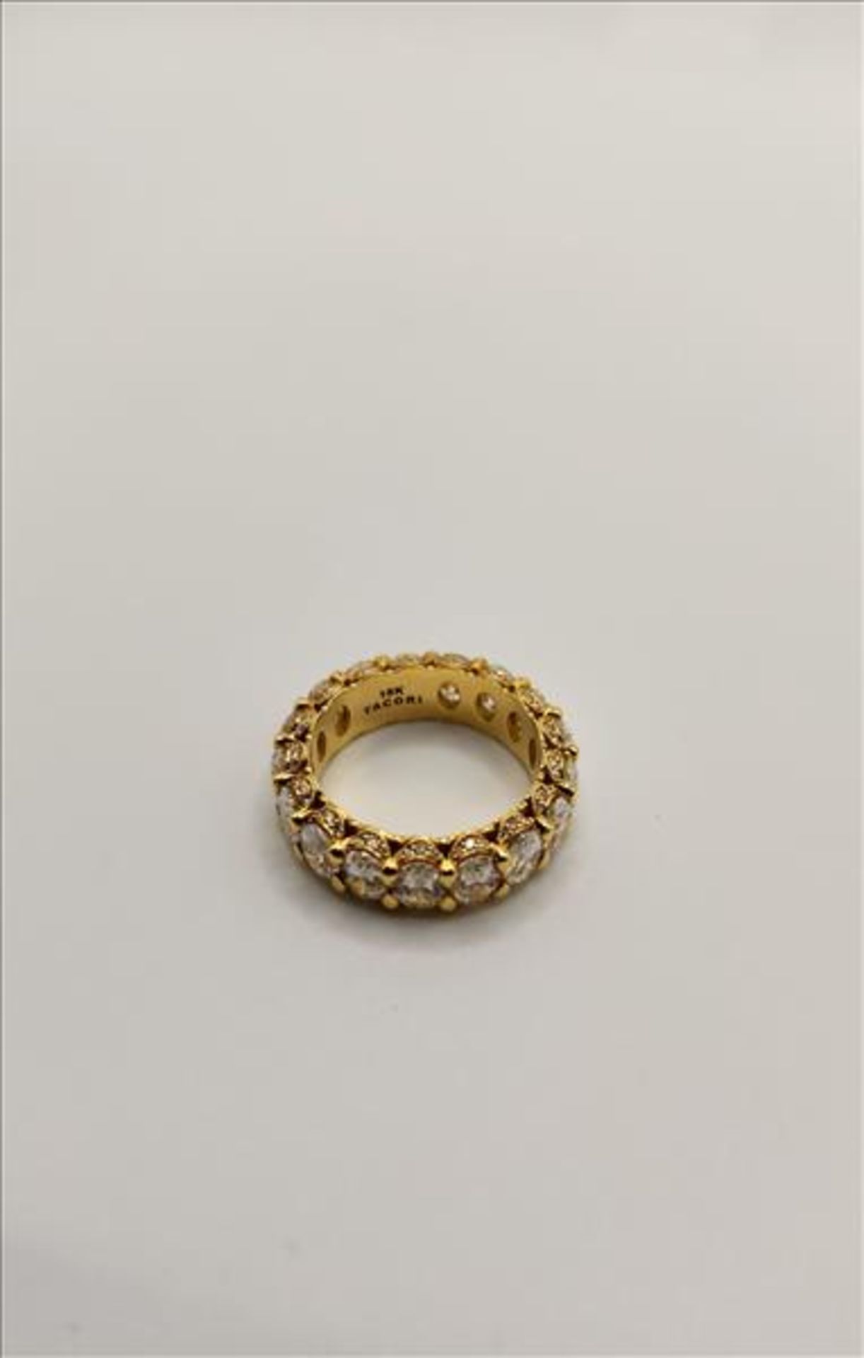 One lady’s stamped 18kt yellow gold “Tacori” diamond eternity band. Shared claw set vertically